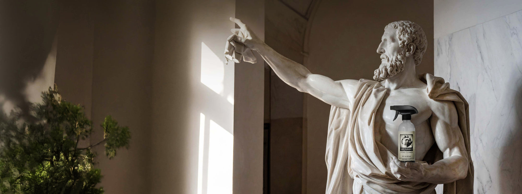 Statue holding a bottle labeled 'Caffè Lavazza' in a classical setting